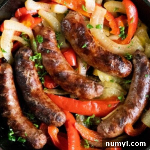 Sizzling Beer Brats with Peppers and Onions 8 Beer brats with peppers and onions in a cast iron skillet.