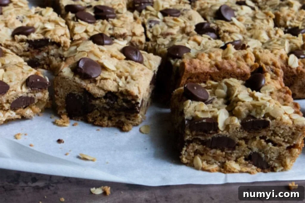 A stack of soft and chewy oatmeal chocolate chip bars, showcasing their golden brown edges and rich chocolate pockets.