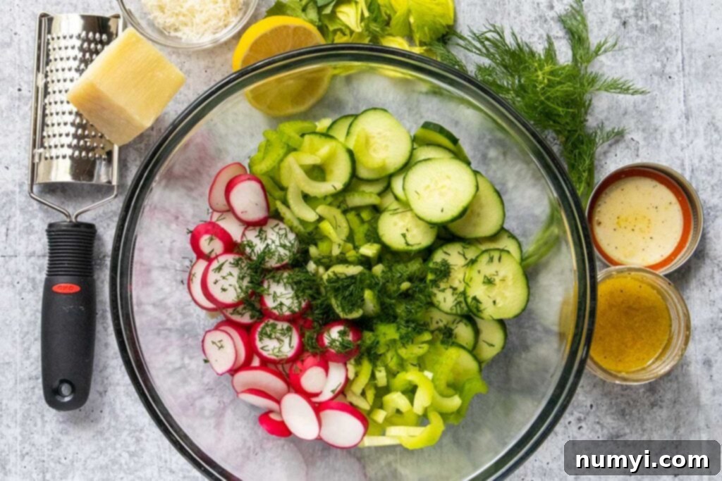 sliced cucumbers, radishes, celery, and chopped fresh dill in a glass bowl
