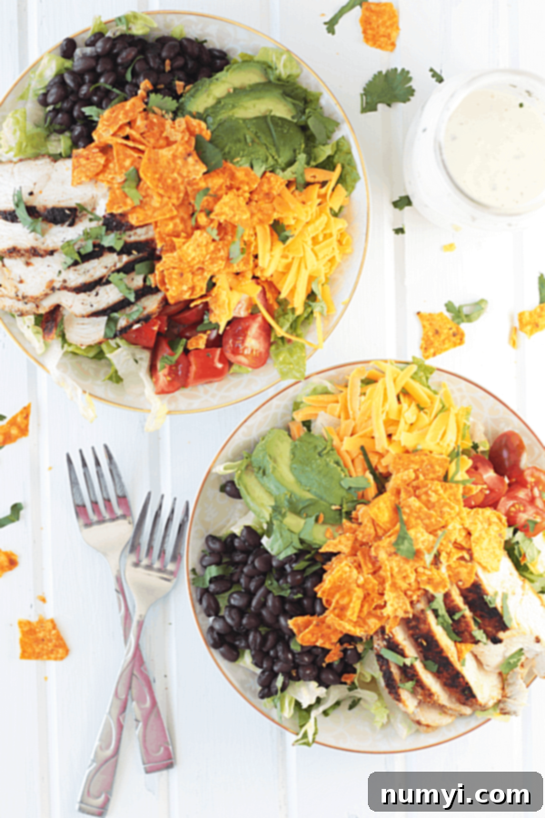 Creamy Ranch Chicken Taco Salad 3 Overhead shot of a vibrant chicken taco salad topped with crushed Doritos, creamy ranch, and fresh cilantro.