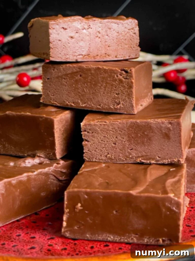 Extra dark chocolate fudge pieces stacked on a plate, showcasing their rich color and smooth texture.