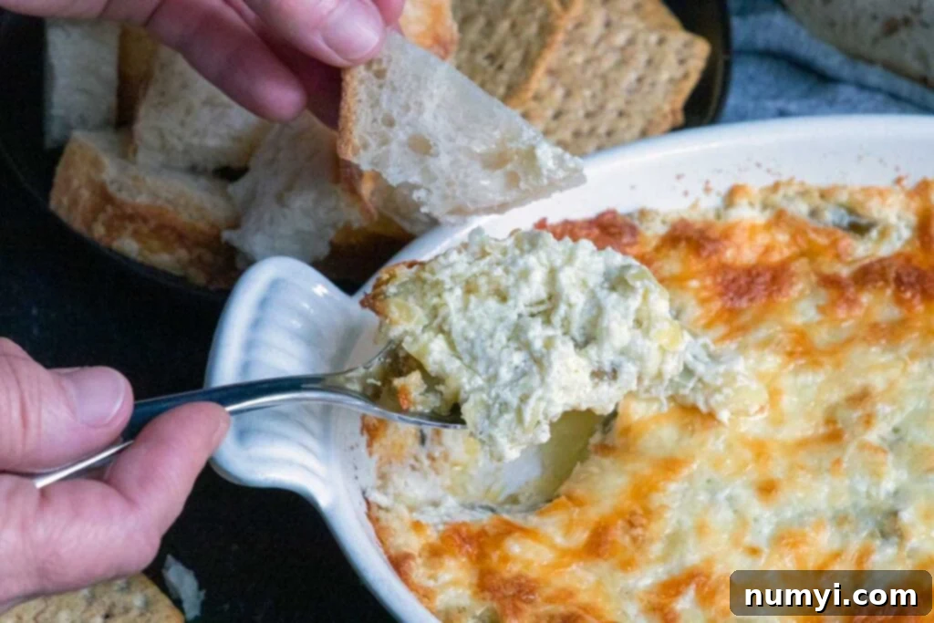 Artichoke dip scooped in a spoon.