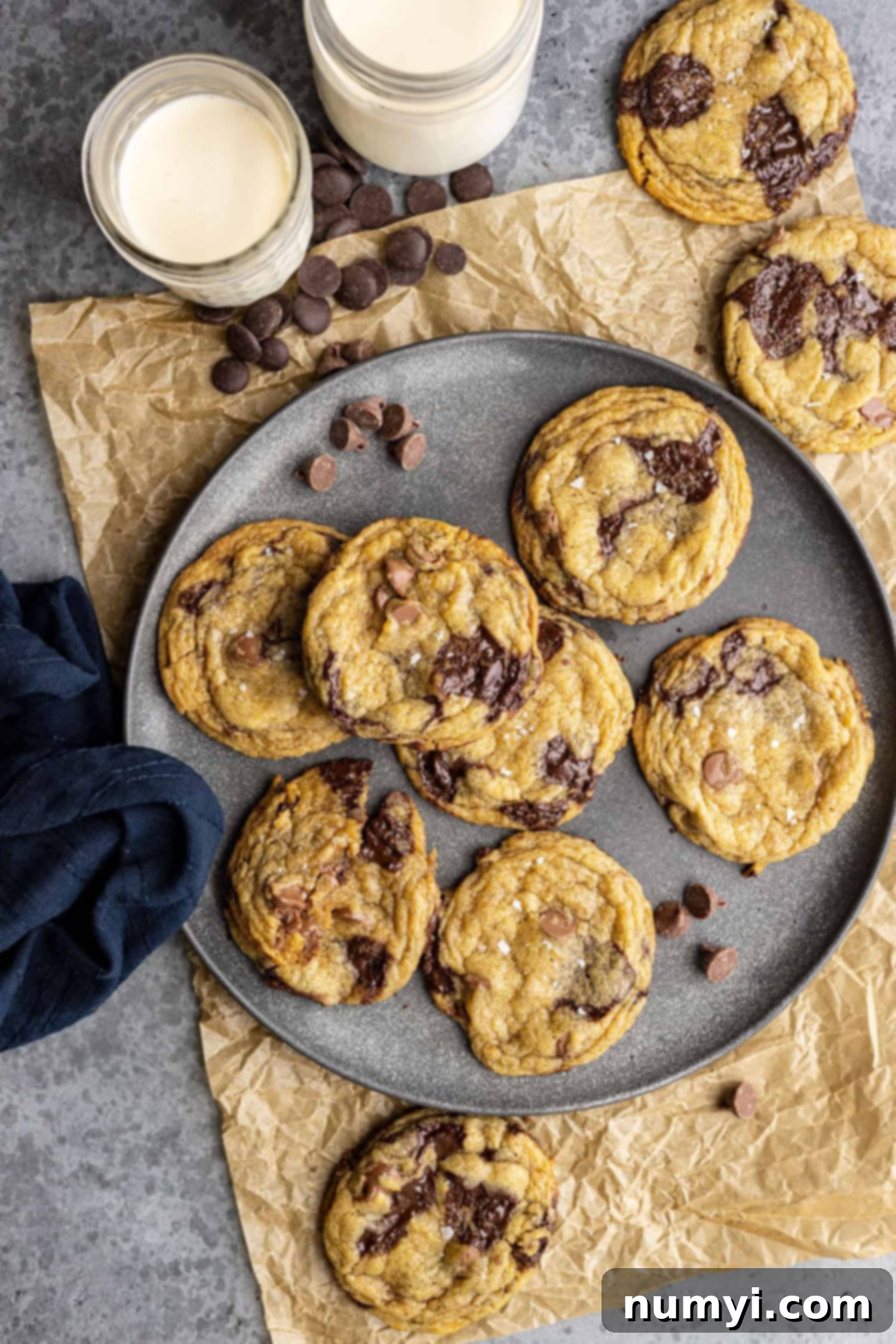 Overhead view of cookies on a plate. Two cups of milk off to the side. 