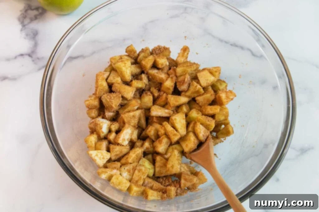 Flaky Apple Strudel Delight 3 Apple strudel filling in a clear glass bowl, showing diced apples and spices.