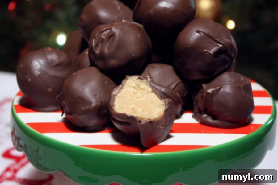 Homemade chocolate peanut butter balls stacked artfully on a festive red and green plate, garnished with a sprinkle of holiday cheer.