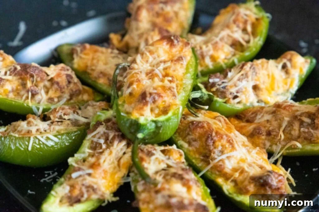 Jalapeno poppers on a black plate.