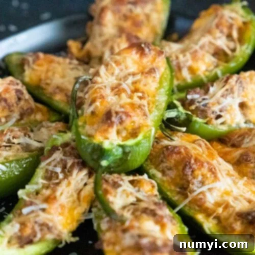Jalapeno poppers on a black plate.
