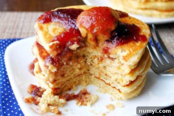 Peanut butter pancakes drizzled generously with homemade jelly syrup