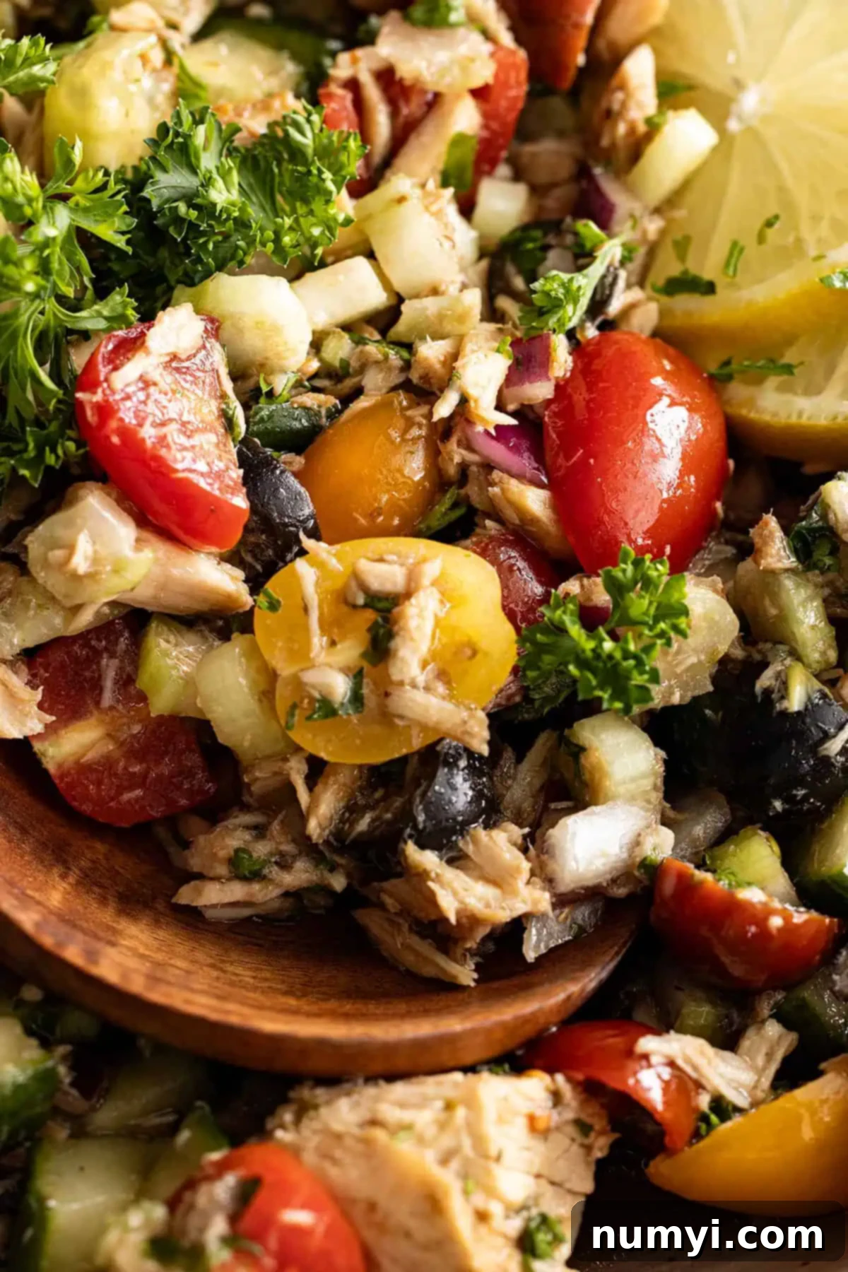 Close up of Mediterranean tuna salad in a white bowl, showing the colorful mix of vegetables and tuna.