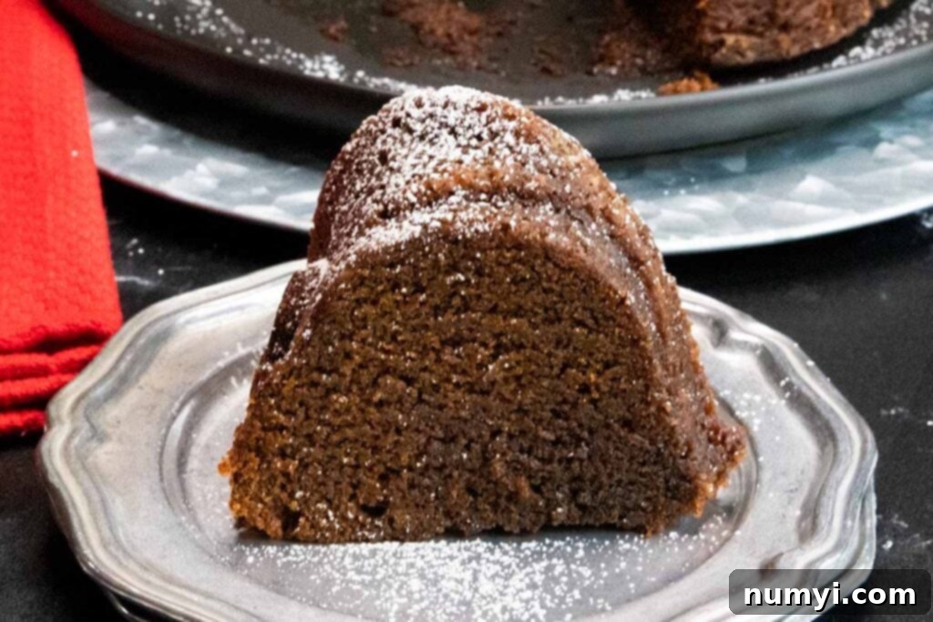 A slice of Gramercy Tavern gingerbread on silver plate garnished with powdered sugar.