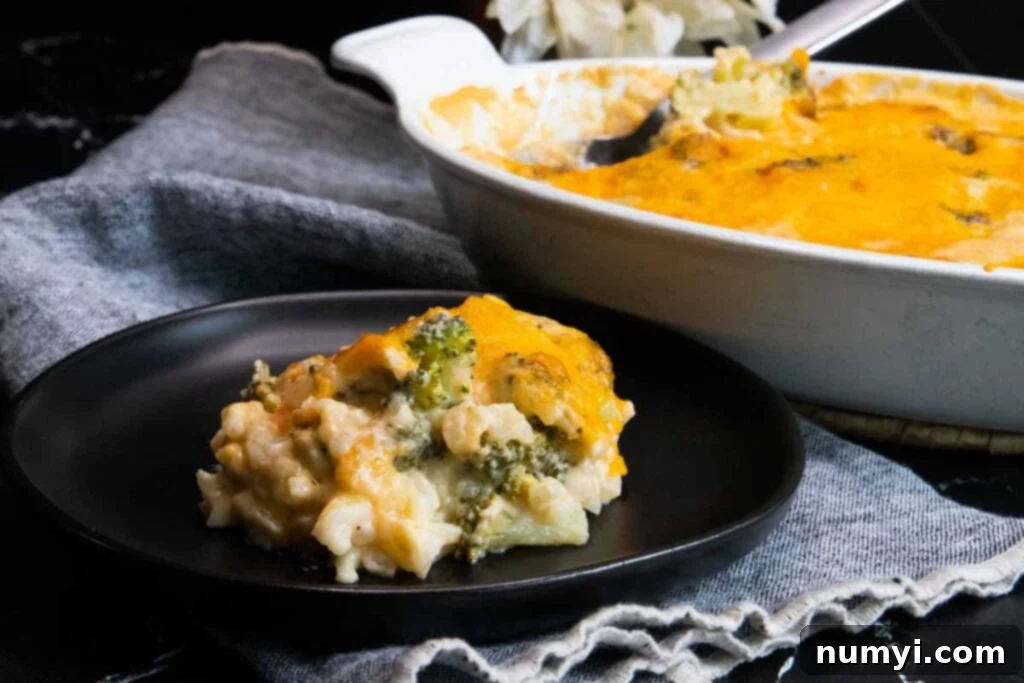 Creamy Broccoli and Cheese Rice Bake 2 A serving of homemade broccoli rice casserole on a black plate, showcasing its creamy texture and golden-brown topping.