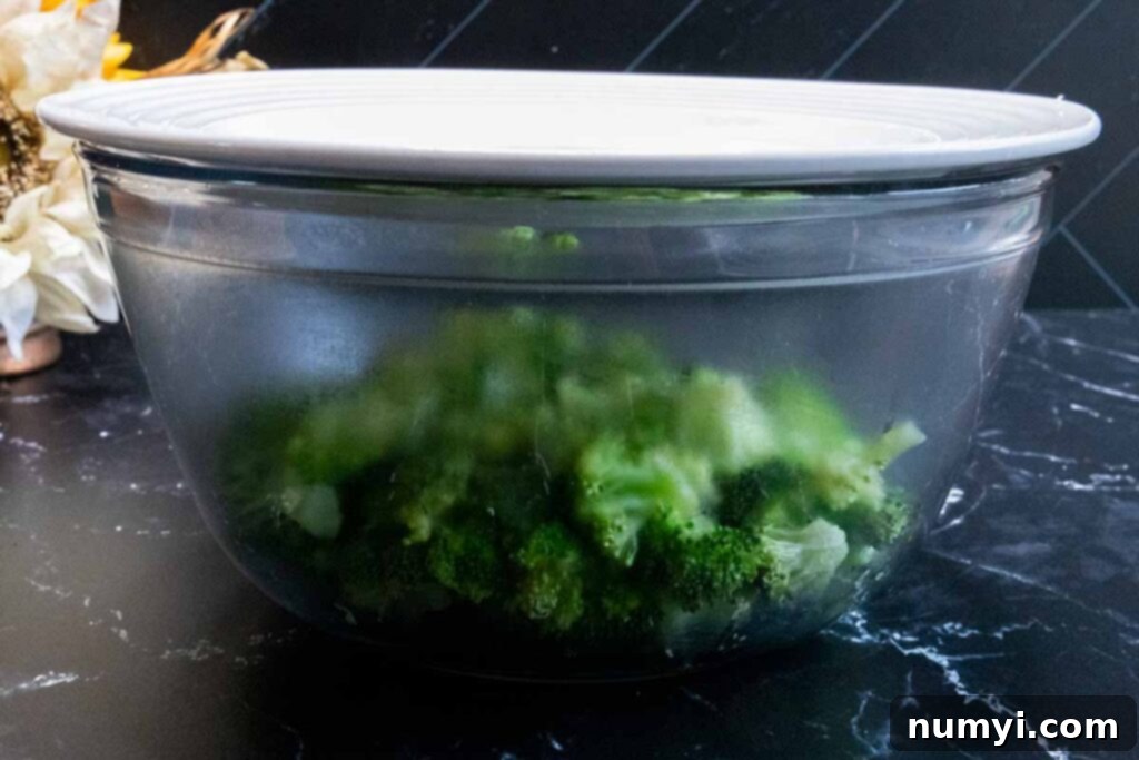 Creamy Broccoli and Cheese Rice Bake 3 Fresh broccoli florets in a glass bowl, prepared for blanching.