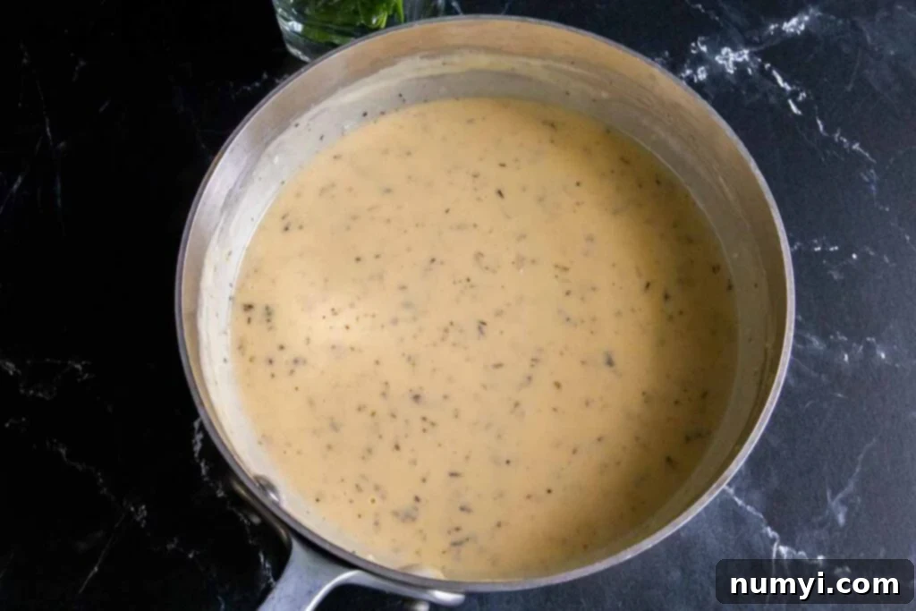 Creamy Chicken and Cheese Spaghetti 4 A close-up shot of the rich, creamy cheese sauce in a saucepan, ready to be combined with the pasta.