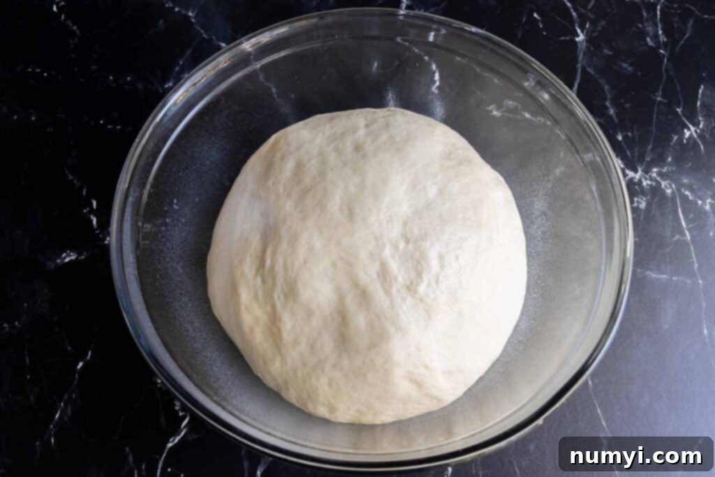 Proofed dough, beautifully risen in a glass bowl.