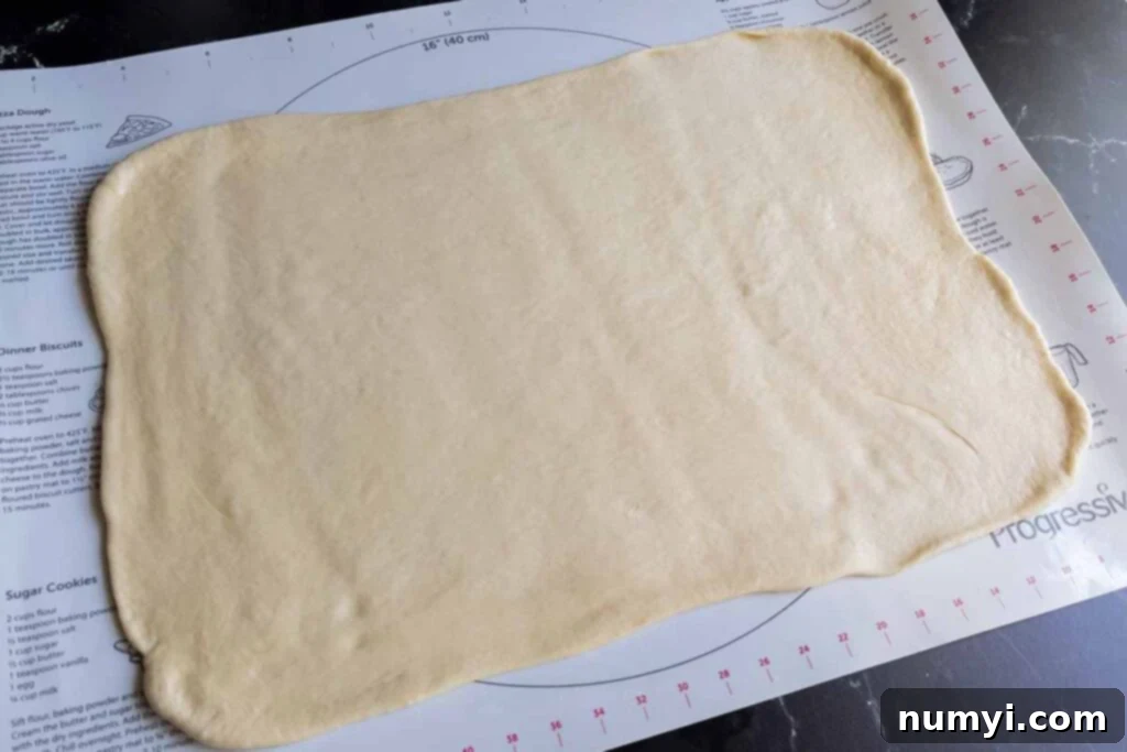Cinnamon roll dough expertly shaped into a rectangle, ready for filling.