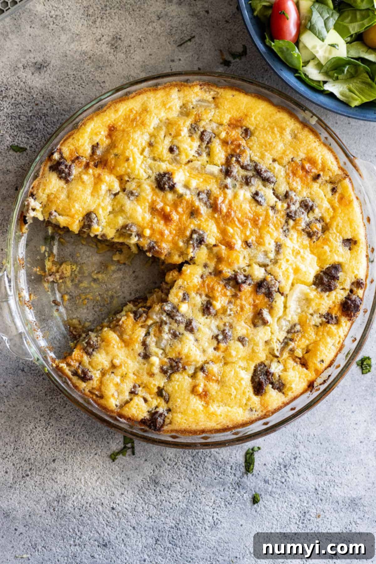 Overhead view of cheeseburger pie with a slice taken out. 
