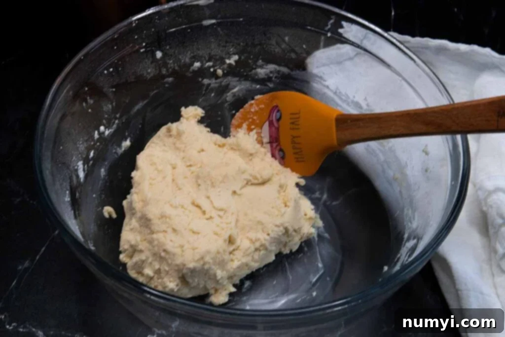 Golden Maple Shortbread Delights 3 Soft cookie dough in a clear glass mixing bowl, ready for shaping and chilling.