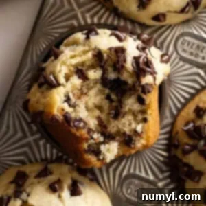 Close up of muffin with bite taken out showing all the chocolate chips inside the muffin.