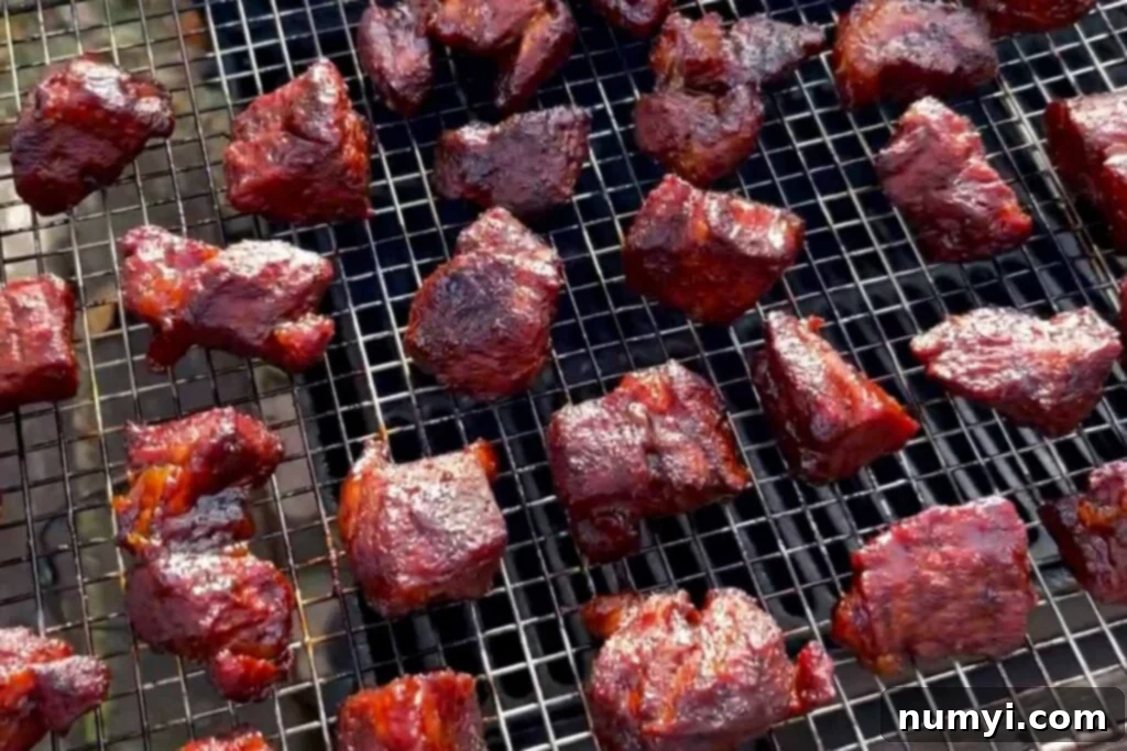 Ultimate Pork Butt Burnt Ends 16 A pan full of freshly smoked and glazed pork butt burnt ends, just removed from the smoker, showcasing their dark, caramelized coating.