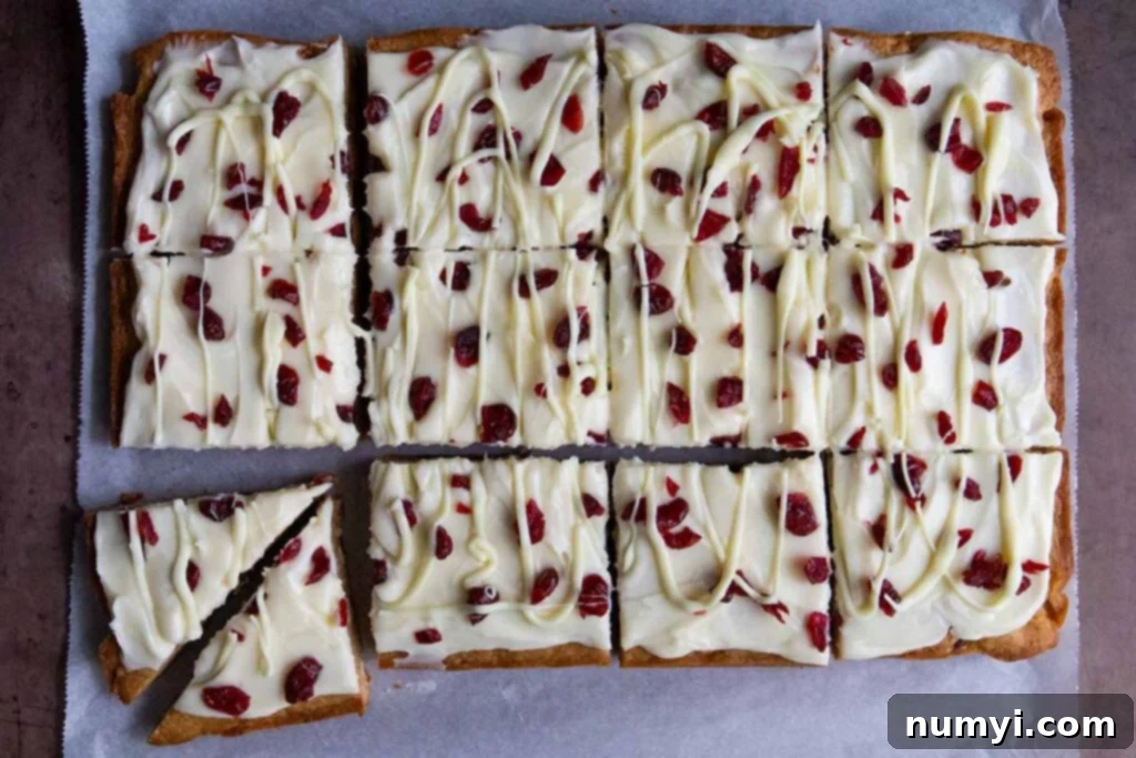 Sliced cranberry bliss bars on parchment paper.
