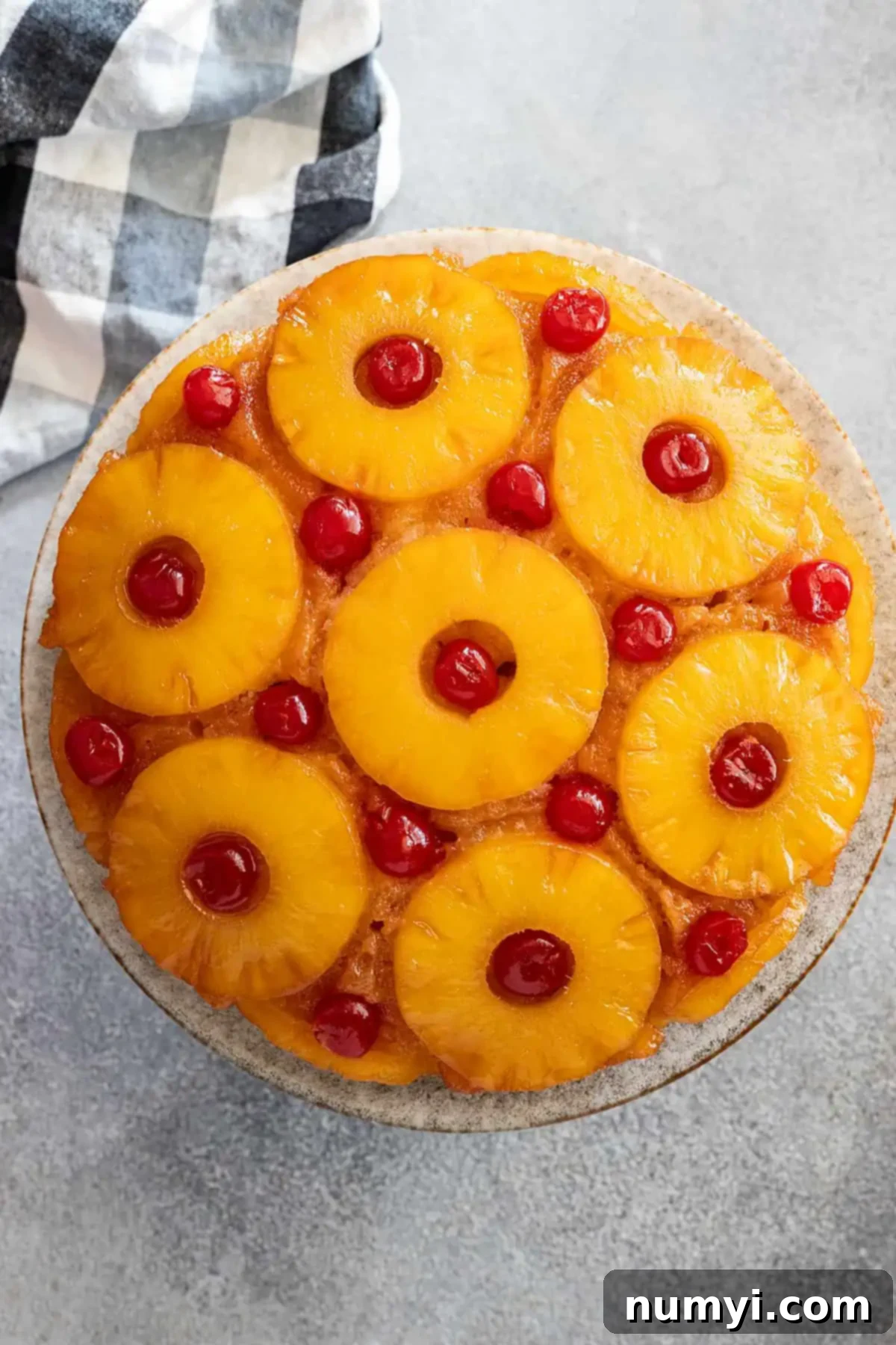Overhead view of a beautifully baked pineapple upside down cake, showcasing its caramelized pineapple and cherry topping.