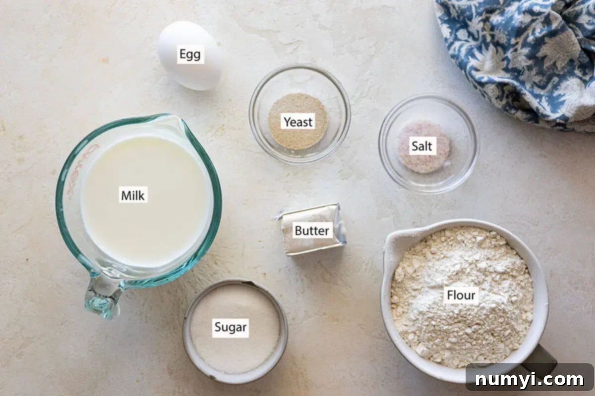 Soft Dinner Rolls 3 Ingredients: Milk, egg, sugar, yeast, salt, butter, and flour neatly arranged on a counter.