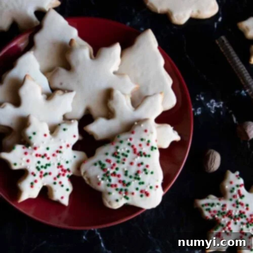 A stack of golden brown eggnog cookies on a red plate, glazed and ready for serving.