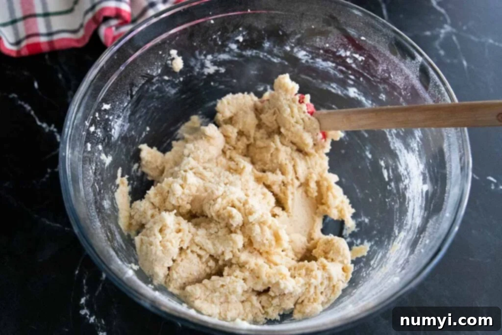 Eggnog cookie dough in a glass mixing bowl, perfectly mixed and ready for chilling.