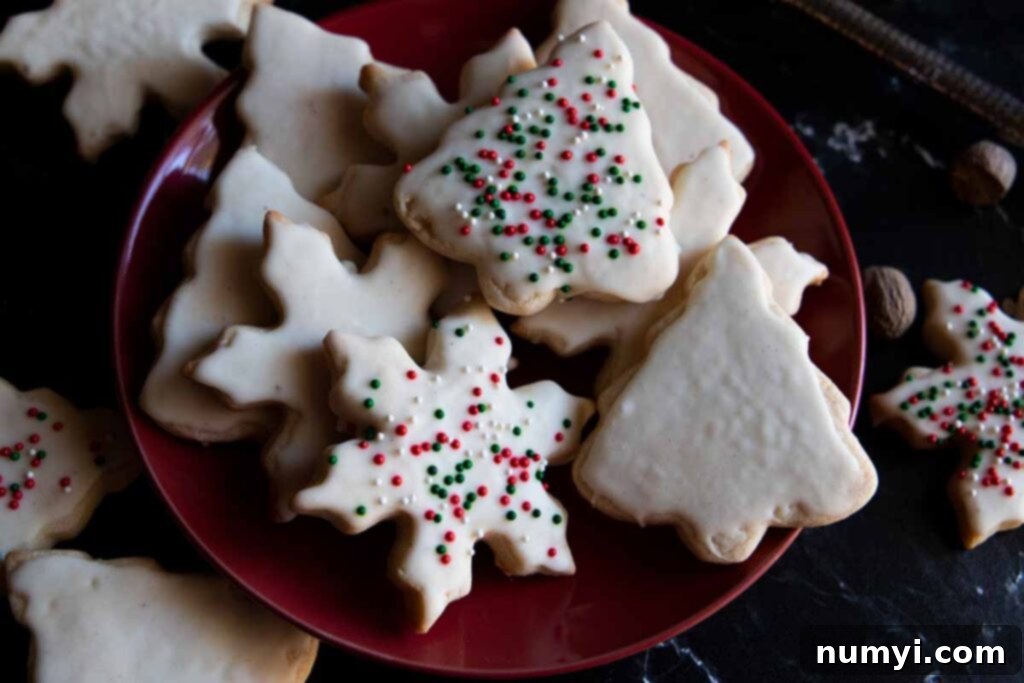 A stack of beautifully glazed and sprinkled eggnog cookies on a festive red plate, ready to be enjoyed.