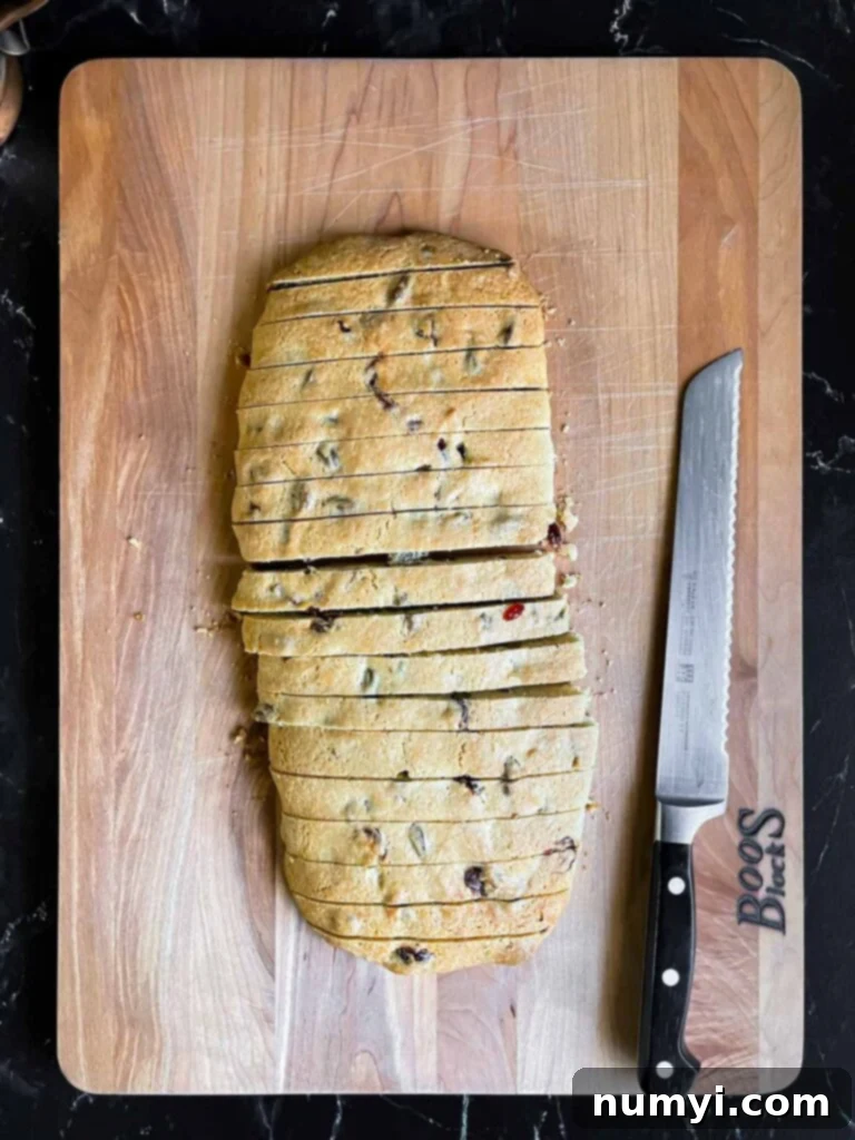Exquisite White Chocolate Cranberry Pistachio Biscotti 9 Cranberry pistachio biscotti sliced into pieces on a wooden board.
