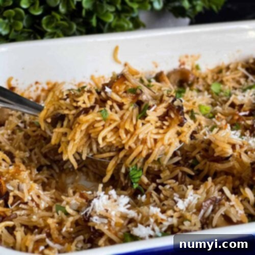 Close-up of fluffy Basmati Rice Risotto (Stick of Butter Rice) in a white casserole dish, garnished with fresh parsley.