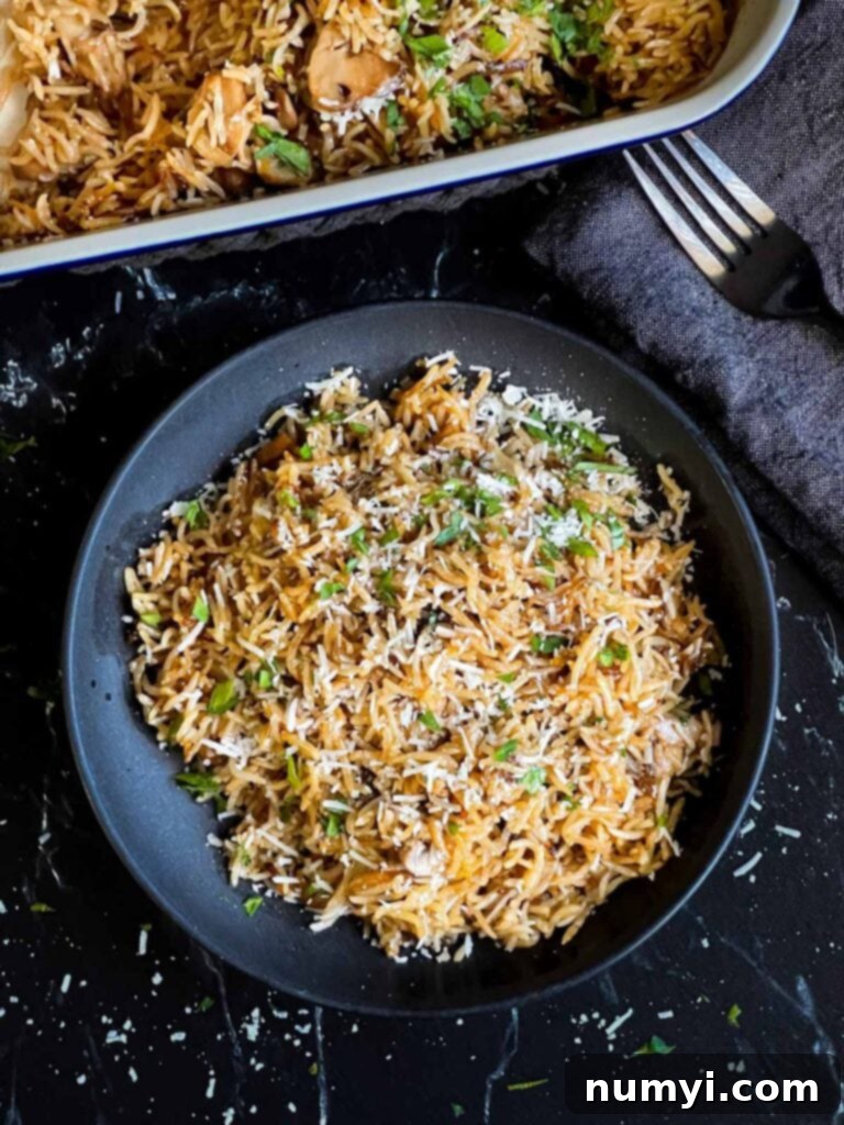 A generous serving of Basmati Rice Risotto, known as Stick of Butter Rice, presented in a dark, elegant serving bowl, ready to be paired with a main course.