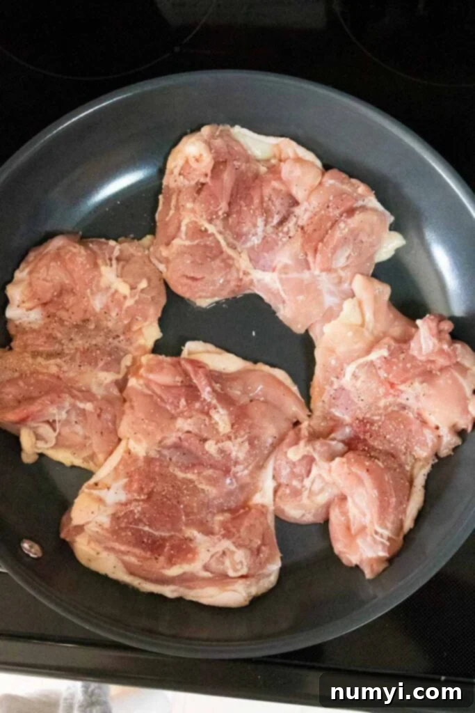 Mouthwatering Golden Crispy Teriyaki Thighs 5 Raw chicken thighs in a skillet