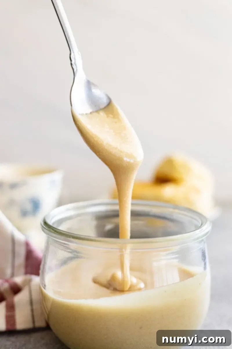 Whip Up Irresistibly Creamy Honey 2 Spoon pulling up whipped honey from a jar.