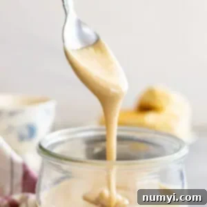 Whip Up Irresistibly Creamy Honey 6 Spoon pulling up whipped honey from a jar.