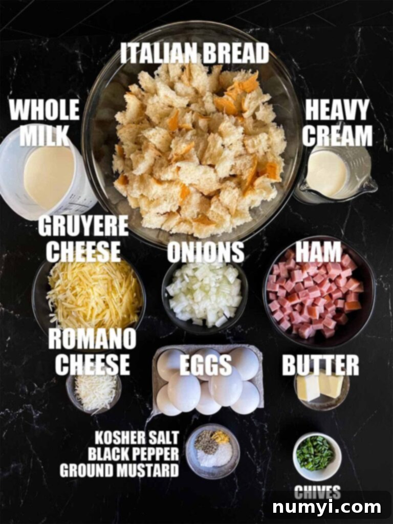 Various ingredients for the ham and cheese strata recipe neatly arranged on a dark surface.