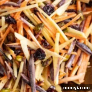 Sunshine Carrot Slaw 6 Close up of a vibrant, creamy carrot salad in a serving bowl.