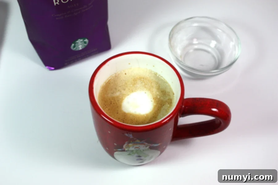 Craft Your Own Holiday Spice Flat White 2 Copycat Holiday Spice Flat White coffee in a Christmas mug, ready to be enjoyed.
