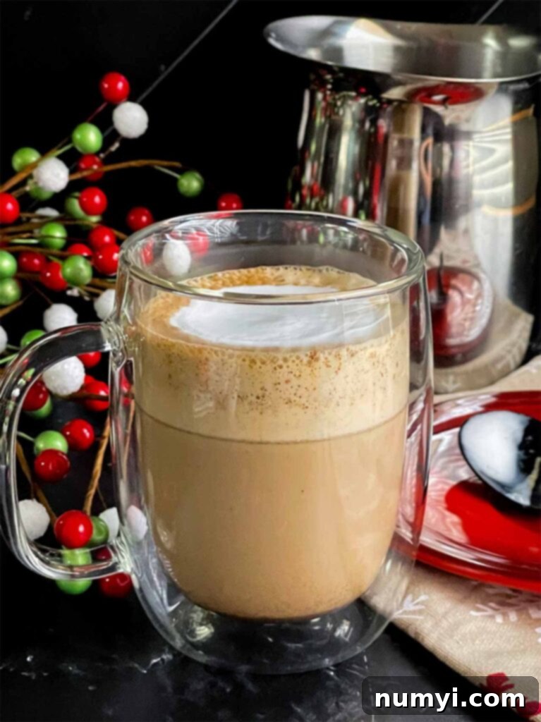 Craft Your Own Holiday Spice Flat White 11 Another view of the Holiday Spice Flat White in a clear glass mug, with subtle lighting, enhancing its inviting appearance.