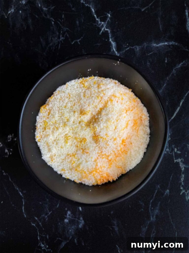 Craft Your Own Holiday Spice Flat White 4 Tangerine zest mixed with granulated sugar in a dark bowl, forming the tangerine sugar.
