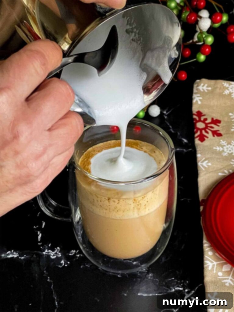Craft Your Own Holiday Spice Flat White 9 Expertly poured steamed milk and foam creating the signature dot in a glass mug with espresso and spices.