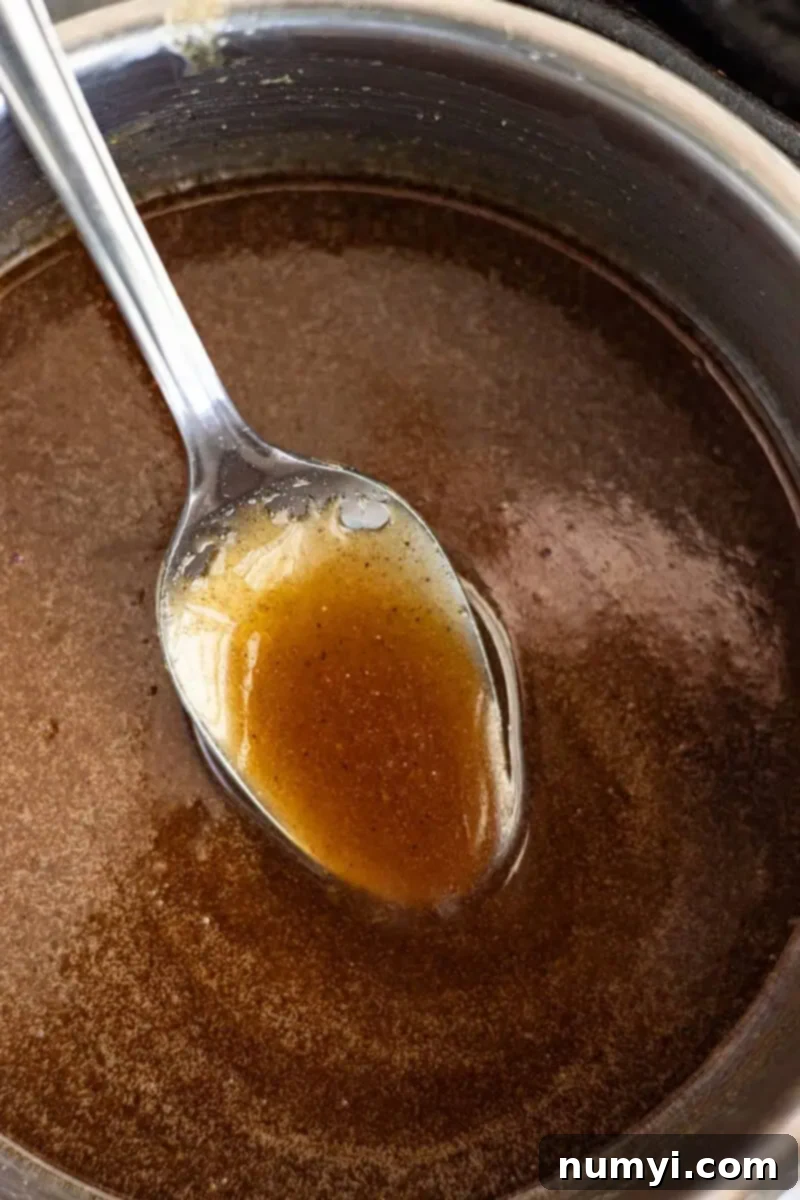 Overhead view of a spoon in the glaze, ready to be applied to a ham.
