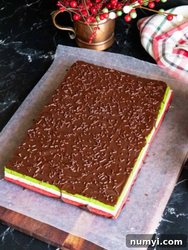 A festive scattering of colorful sprinkles over the freshly melted chocolate coating on the Italian rainbow cookie, adding a delightful visual appeal.