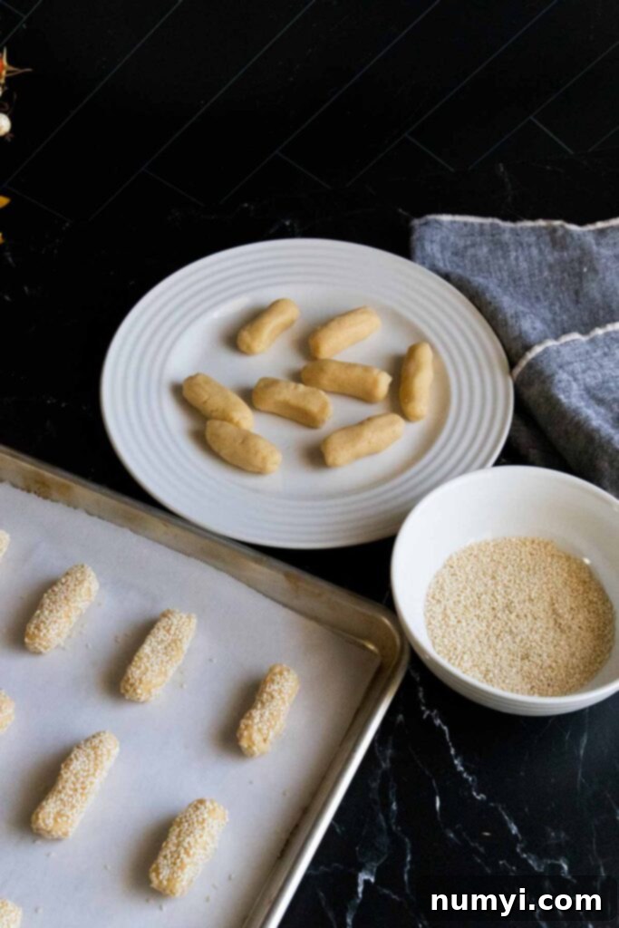 Biscotti Regina Italian Sesame Seed Cookies 5 Sesame cookie dough logs arranged on parchment paper-lined baking sheet before baking.