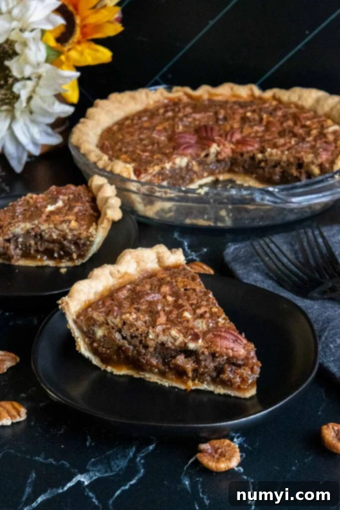 Slices of pecan pie on black plates.