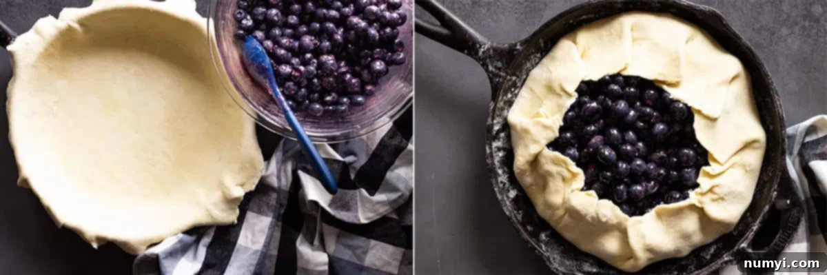 Overhead view demonstrating the process of filling a pie crust with blueberries and folding the edges of the dough over the fruit to create a galette.