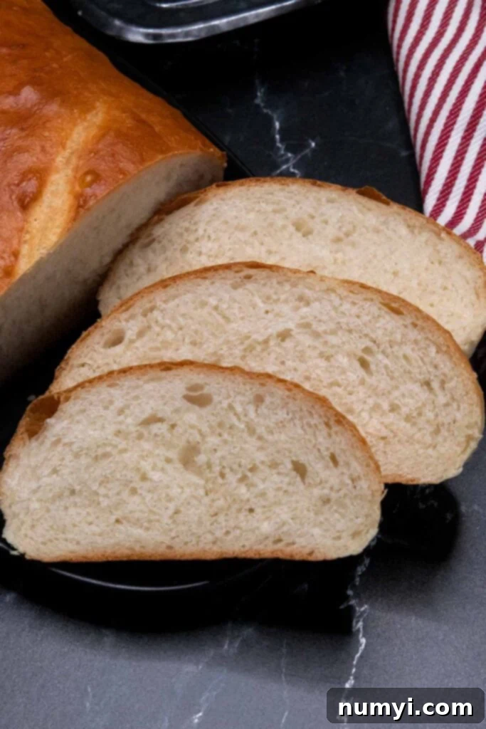 Several slices of soft, fluffy Italian bread arranged neatly on a black platter, ready for serving.