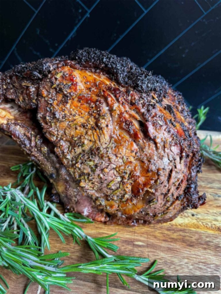 Closed Oven Prime Rib Roast 6 Beautifully cooked prime rib roast with a golden crust, resting on a wooden cutting board.