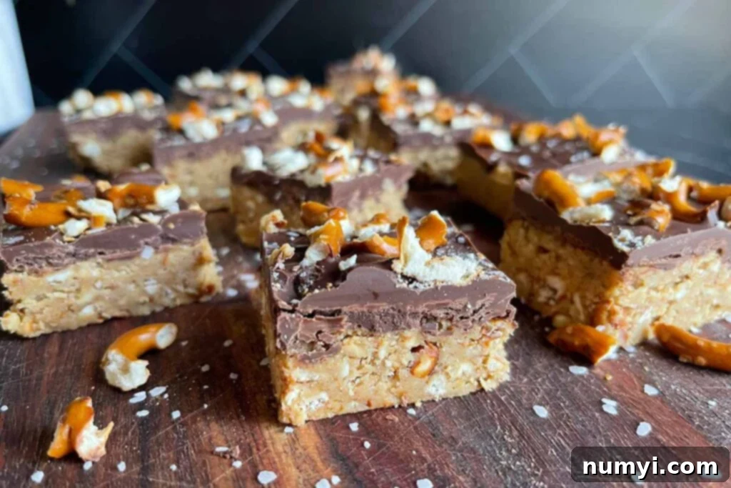 Salty Sweet Peanut Butter Pretzel Bars 2 Peanut butter pretzel bars on a dark wooden board, ready to be enjoyed.
