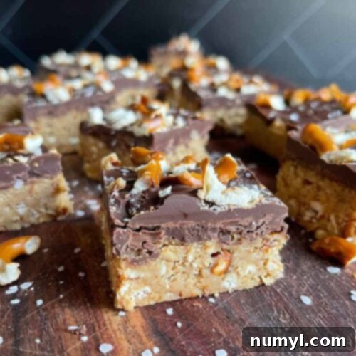 Salty Sweet Peanut Butter Pretzel Bars 10 Peanut butter pretzel bars on a dark wooden board.